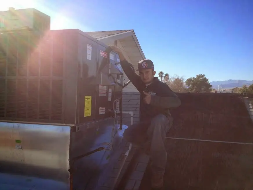 HVAC technician performing Heat Pump Repair on a rooftop unit in Valley City