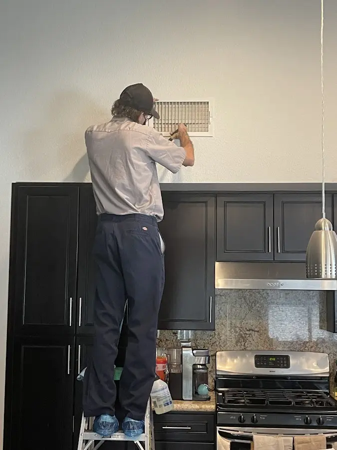 Technician inspecting an air vent during HVAC service in Valley City